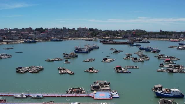 An aerial video of a fishing village and port on a sunny day