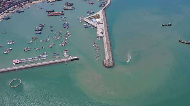 An aerial video of a fishing village and port on a sunny day