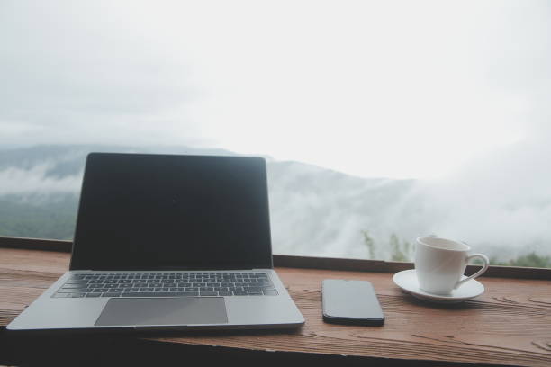 istock Young man freelancer traveler wearing hat anywhere working online using laptop and enjoying mountains view 1595659327