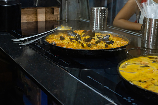 Typical Spanish Paella with mussels and prawns in a kitchen.