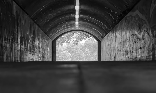 View out of a tunnel, light at the end of the tunnel, black and white, horizontal