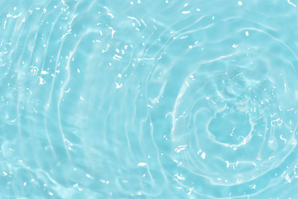 istock Blue water with ripples on the surface. Defocus blurred transparent blue colored clear calm water surface texture with splashes and bubbles. Water waves with shining pattern texture background. 1595756178