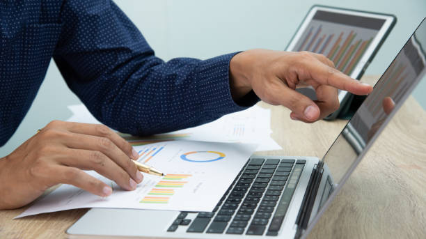 istock Businessman working at office with digital tablet, laptop computer, smart phone. Professional investor connection internet application online. Businessmen review annual company report. 1595812935