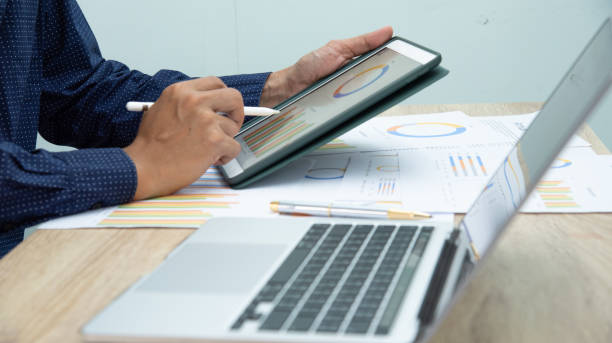istock Businessman working at office with digital tablet, laptop computer, smart phone. Professional investor connection internet application online. Businessmen review annual company report. 1595812945