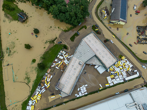 Extreme river flooding from a powerful storm - flooding houses, residential buildings, industrial zones, cars, roads and highways. Water destroying lives and everything in its way. Endless water damage in Slovenia, 2023. Aerial view of floods.