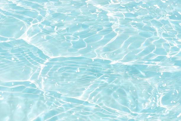 istock Blue water with ripples on the surface. Defocus blurred transparent blue colored clear calm water surface texture with splashes and bubbles. Water waves with shining pattern texture background. 1595879936