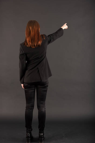 Woman pointing at blackboard / wall