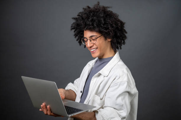 istock Young freelance with a laptop on grey background 1595908362