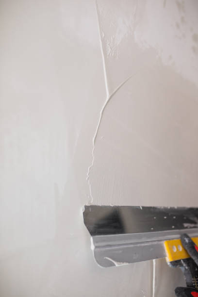 istock The finisher makes the surface of the wall even and smooth 1595913861