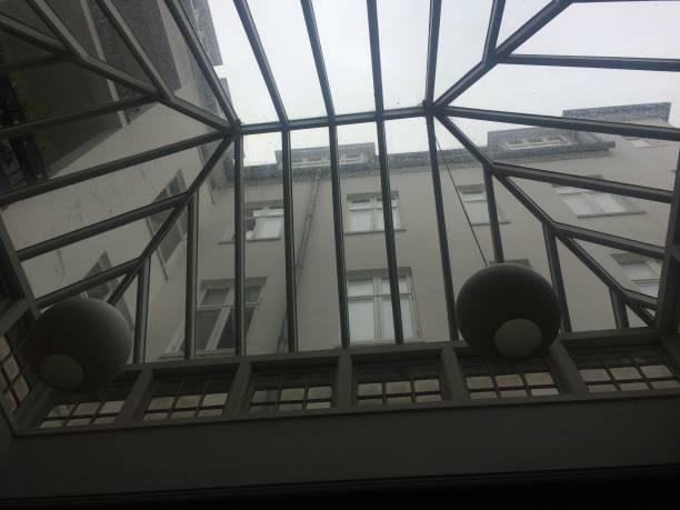 istock Low angle view through a window that is formed like a small greenhouse. looking on a building. 1595934042