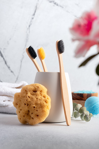 Eco-friendly bathroom accessories: bamboo toothbrushes and natural sea sponge. Zero waste spa and bath products.