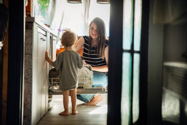 istock Mother and baby boy by the dishwasher 1595954484