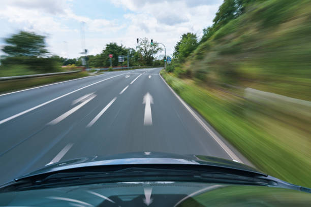 LOW ANGLE, CLOSE UP: Cool curb shot of a metallic blue car racing down the asphalt track on a sunny autumn day. Sportscar speeds along a sweeping circuit turn with a striking red and white curb.
