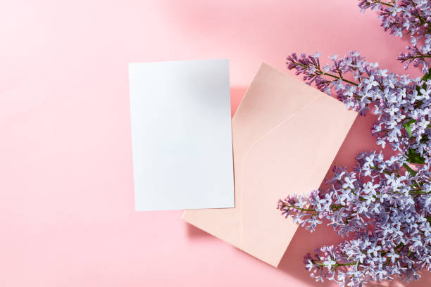 istock Mockup white greeting card and envelope with lilac branches on a pink background 1595995153