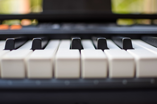 Close-up of piano keys. Piano black and white keys and Piano keyboard musical instrument placed at the home balcony during sunny day.