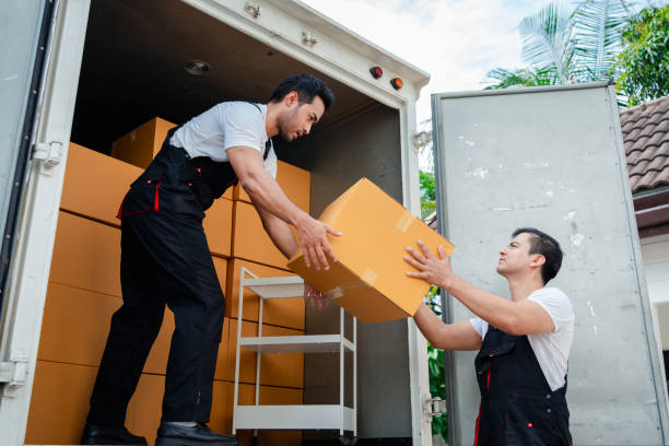 descarregando caixas e móveis de uma caminhonete para uma nova casa com carga de serviço dois homens trabalhadores em caixas de elevação uniformes. conceito de home moving e delivery. - moving service - fotografias e filmes do acervo