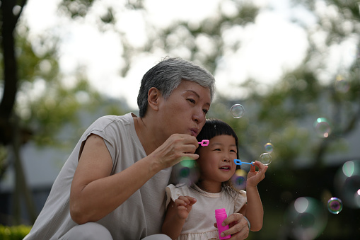 Loving Moments OutdoorsWith Asian Grandmother And Grandchildren