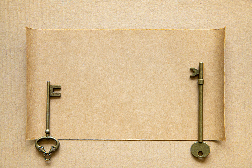 The old key and compass on brown paper background