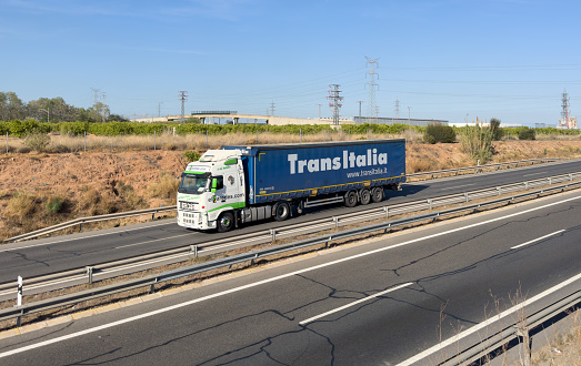 Semi truck by TransItalia with Semi-trailer driving along highway. Goods Delivery by roads. Services and Transport logistics. Import - Export. April 12, 2023, Spain, Port Sagunto.