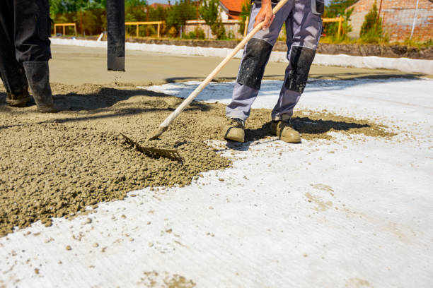 istock Rigger, worker is using rake to level fresh concrete into building foundation over reinforcing steel bars 1596122234