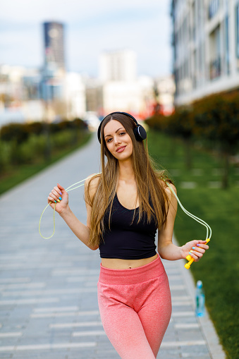 Portrait of a Beautiful Young Woman with Jump Rope who is Listening to the Music.