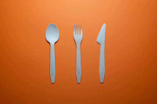disposable wooden cutlery on orange background
