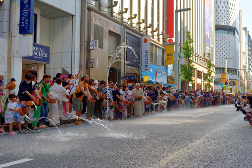 Tokyo, Japan-August 5, 2023\nSprinkling of water in Ginza, Tokyo, in order to cool down the summer heat. People are asked to sprinkle water, to the tune of drum-beat, performed by professional  female drummers.   \nThis event, called Uchimizu in Japanese, takes place on the last weekend of July, or first weekend of August, annually, with many men and women turning up in yukata, traditional Japanese summer kimono.\nAfter 2 years' absence due to VOVID-19 pandemic, the event was resumed in the summer of 2022.