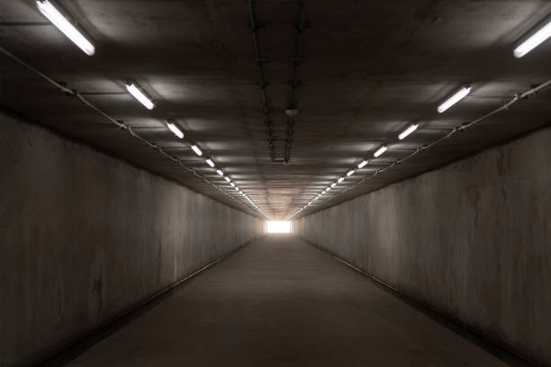 istock underground concrete tunnel and bright light at the destination 1596173559