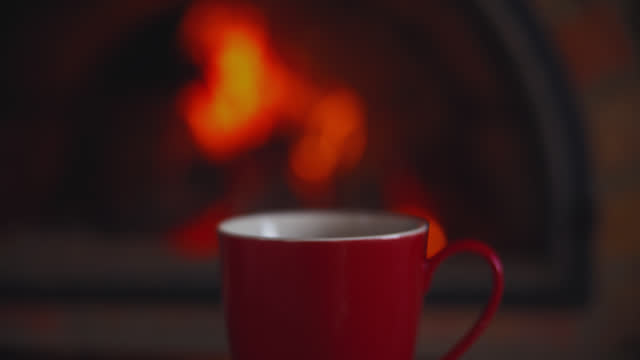 DS A cup of tea with a background of a fireplace with flames of fire