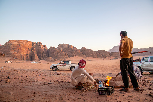 Wadi Rum, Jordan - July, 2023: Bedouins making tea at sunset in the desert of Wadi Rum.