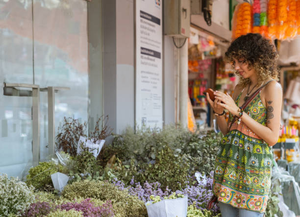 istock Tourist Mesmerized by Market Stall Flowers During Vacation. 1596200445