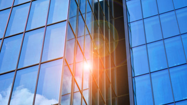 istock Structural glass wall reflecting blue sky. Abstract modern architecture fragment. 1596243609