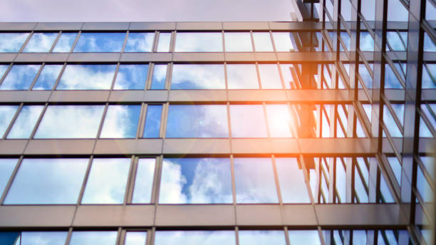 istock Structural glass wall reflecting blue sky. Abstract modern architecture fragment. 1596244691