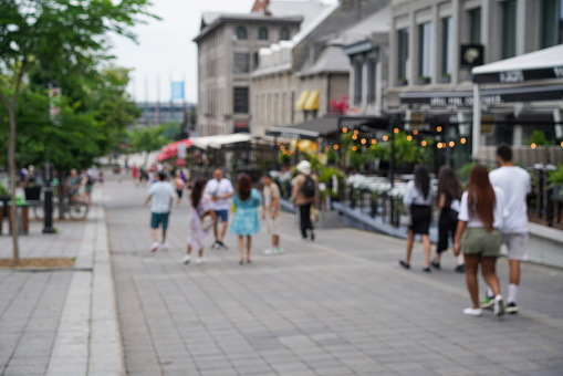 Defocused shot of people walking the streets of Old Montreal. Shot in the morning in early summer.
