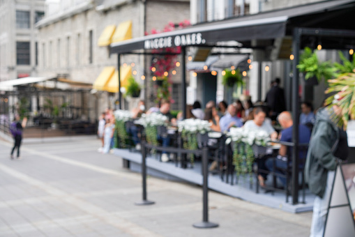 Defocused shot of people dining outdoors in Old Montreal. Shot in the morning in early summer.