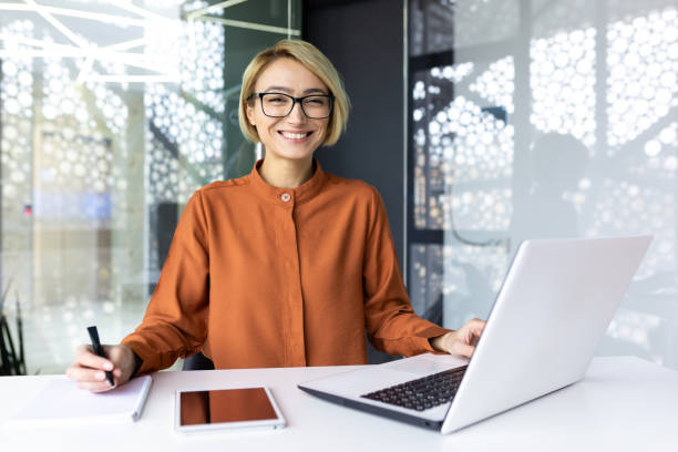 istock Businesswoman working inside office with documents and laptop, worker paperwork calculates financial indicators smiling and happy with success and results of achievement and work 1596264725