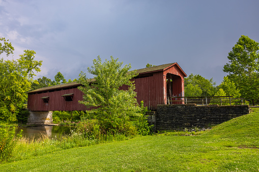 An old red covered bridge over a creek in Indiana.