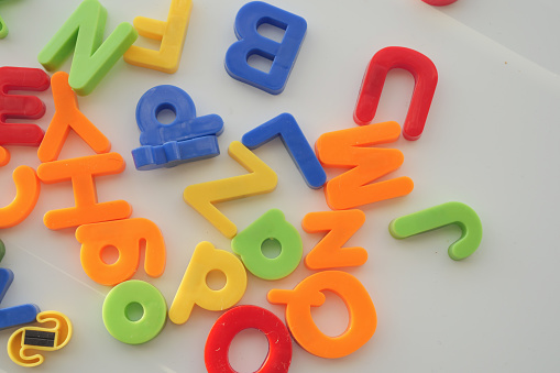 colorful plastic letters on white background, close up .