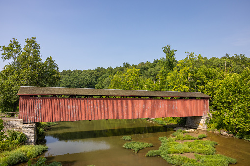 An old red covered bridge over a creek in Indiana.