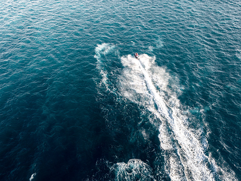 Aerial view of jet skier racing through waves in the adriatic sea. Water racing on jet-skis.