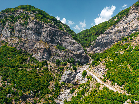 Gravel road leading through albanian mountains, beautiful nature.