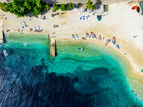 Aerial view full of kayaks, windsurfers and kites and people swimming with sandy beaches in Croatia, Adriatic sea.