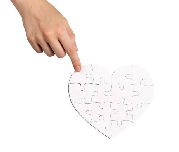 Photo of Completing fixing heart shaped puzzle isolated on white background. Love and family psychology concept