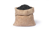 Black sesame seeds in sack bag isolated on white