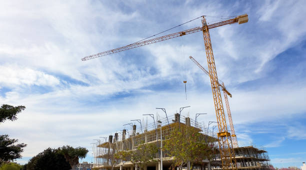 istock Tower crane on construction site. Towhouse under construction. Building onstruction at Mediterranean sea. 1596337776