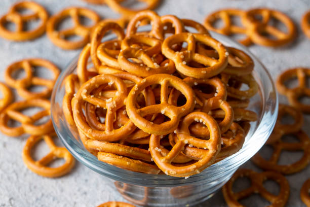 istock Mini pretzels with salt on wooden background. Selective focus. 1596384915