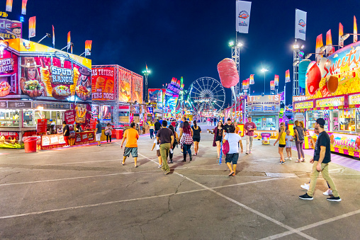 People throng the midway at the Arizona State Fair during the evening hours.