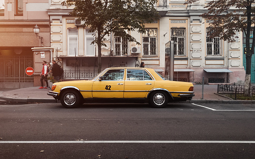 Side profile view of the classic 1970s sedan parked on city street.