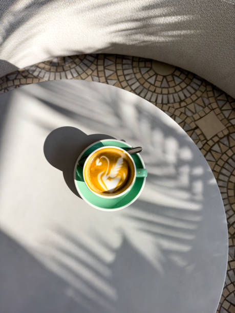 Flat white coffee in palm shadows