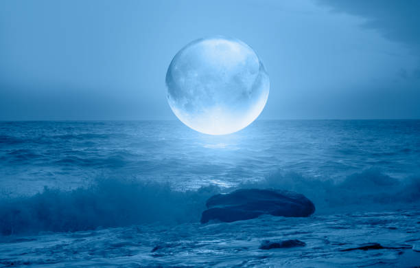 istock Full crystall moon (or glass ball moon) rising over empty sea with night 1596423017